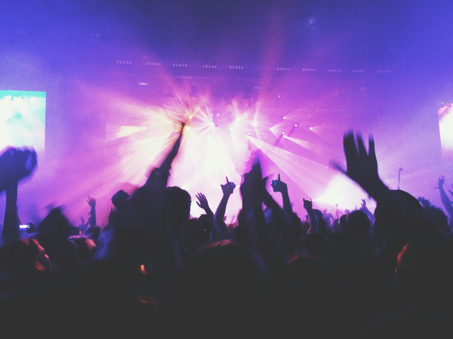 A large outdoor function crowd gathered under warm event lighting after dark.